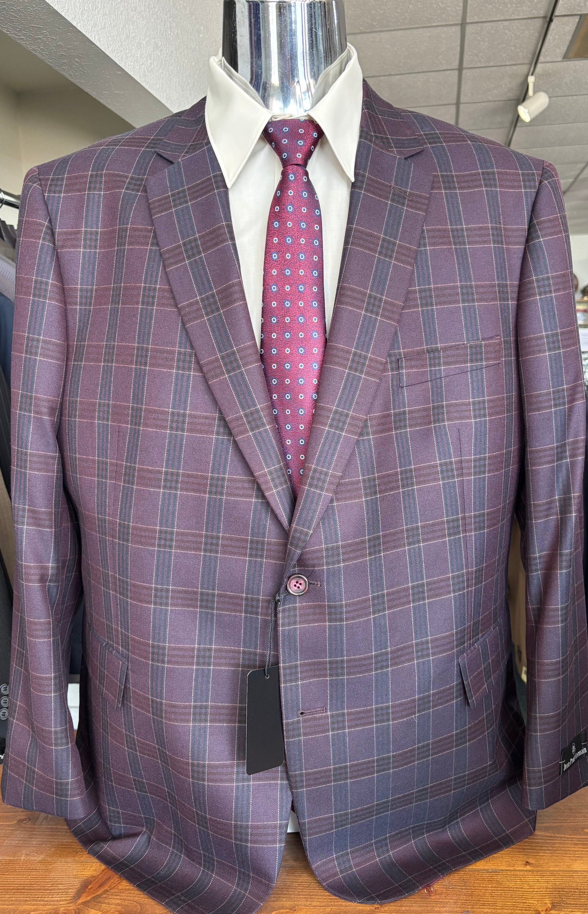Purple checkered suit with a pink tie on a mannequin against a neutral background